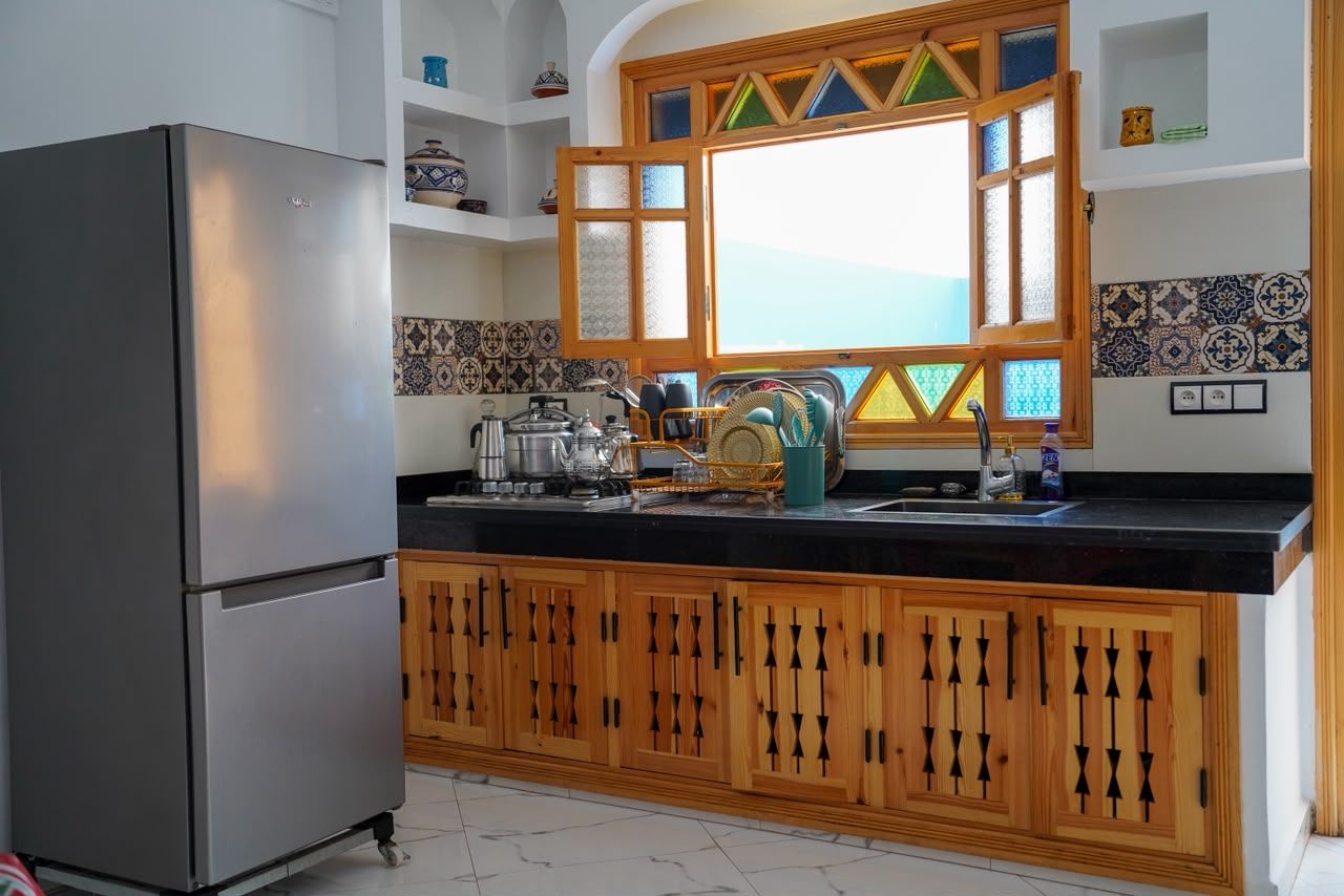 Kitchen with carved wooden cabinets and zellige